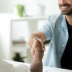 Dois rapazes se cumprimentando com aperto de mãos, representando o tema Empréstimo Pessoal vale a pena.