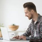 servidor sentando em frente ao computador solicitando um empréstimo consignado SIAPE