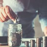 Homem colocando dinheiro em um potinho, representando o conceito de planejamento financeiro familiar.