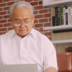 Idoso mexendo no notebook, buscando informações sobre empréstimo consignado.