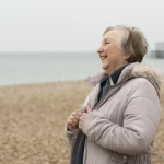 Idosa sorrindo na praia o que é aposentadoria híbrida?