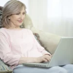 Mulher idosa mexendo no computador aprendendo a como simular sua aposentadoria