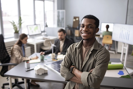 Homem no trabalho, com os braços cruzados e sorrindo, representando o código 1406 INSS.